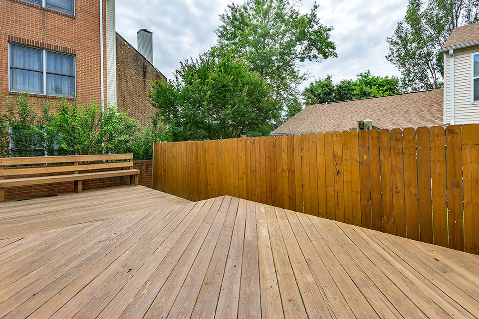 Sunny rear deck with built-in seating and access to the fenced yard